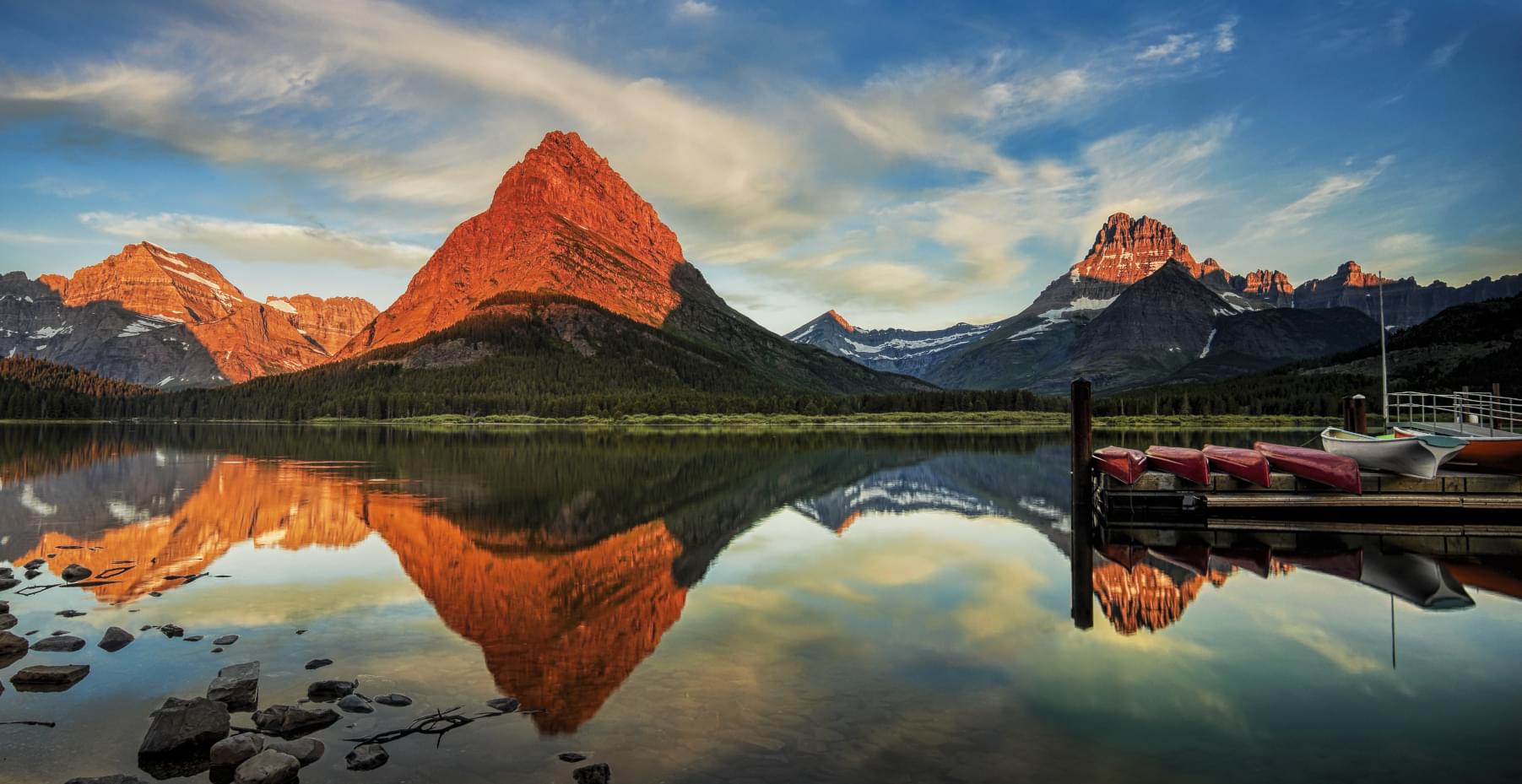 canoes on the dock with glaciers and mountains