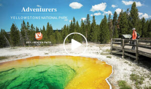 female traveler looking over thermal feature in yellowstone national park as part of an off the beaten path group adventure